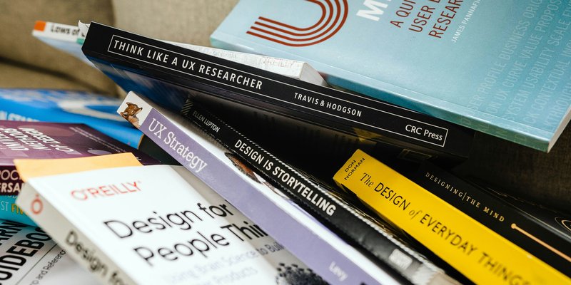 Design books scattered on a table show their titles