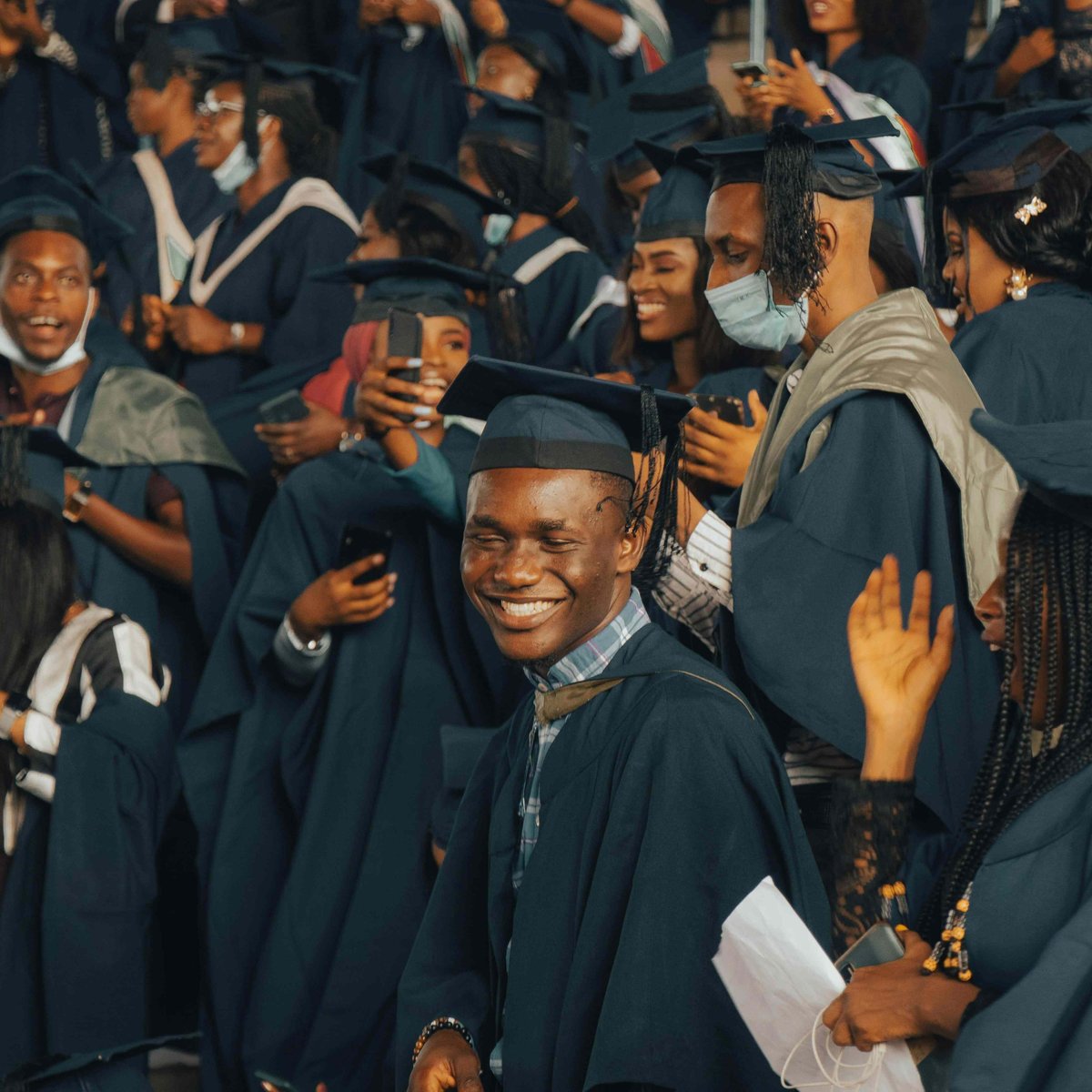 Several African students at a graduation ceremony wearing graduation regalia.