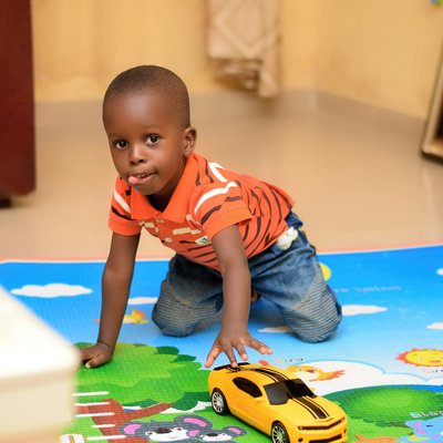 African toddler in elementary school playing with car toy